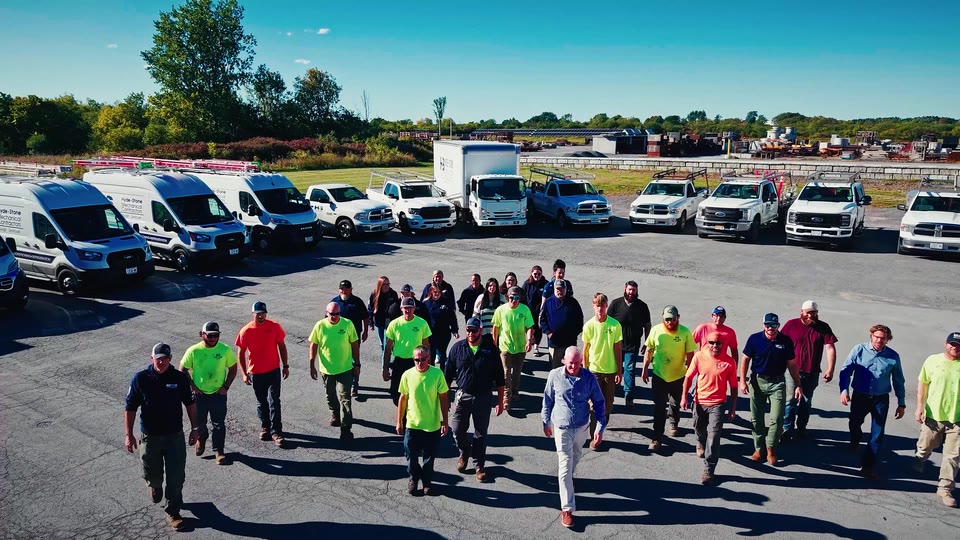 The Hyde Stone team beside a row of company vehicles.